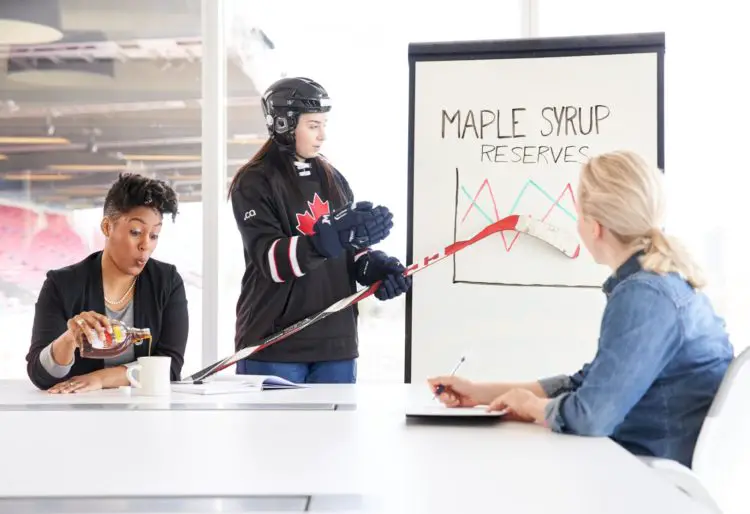 Colleague enjoys tasty glass of maple syrup during presentation by hockey player - Photo by Canadian Internet Registration Authority (CIRA)